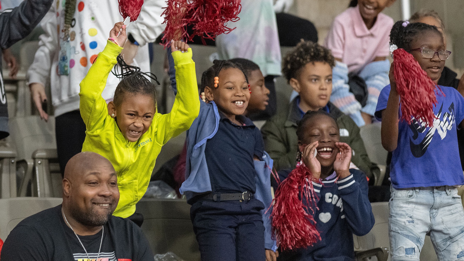 Children cheer on the IU Indy Jaguars at the men's basketball season opener. The students attended the game and a pep rally as part of the NCAA Readers Become Leaders literacy program.