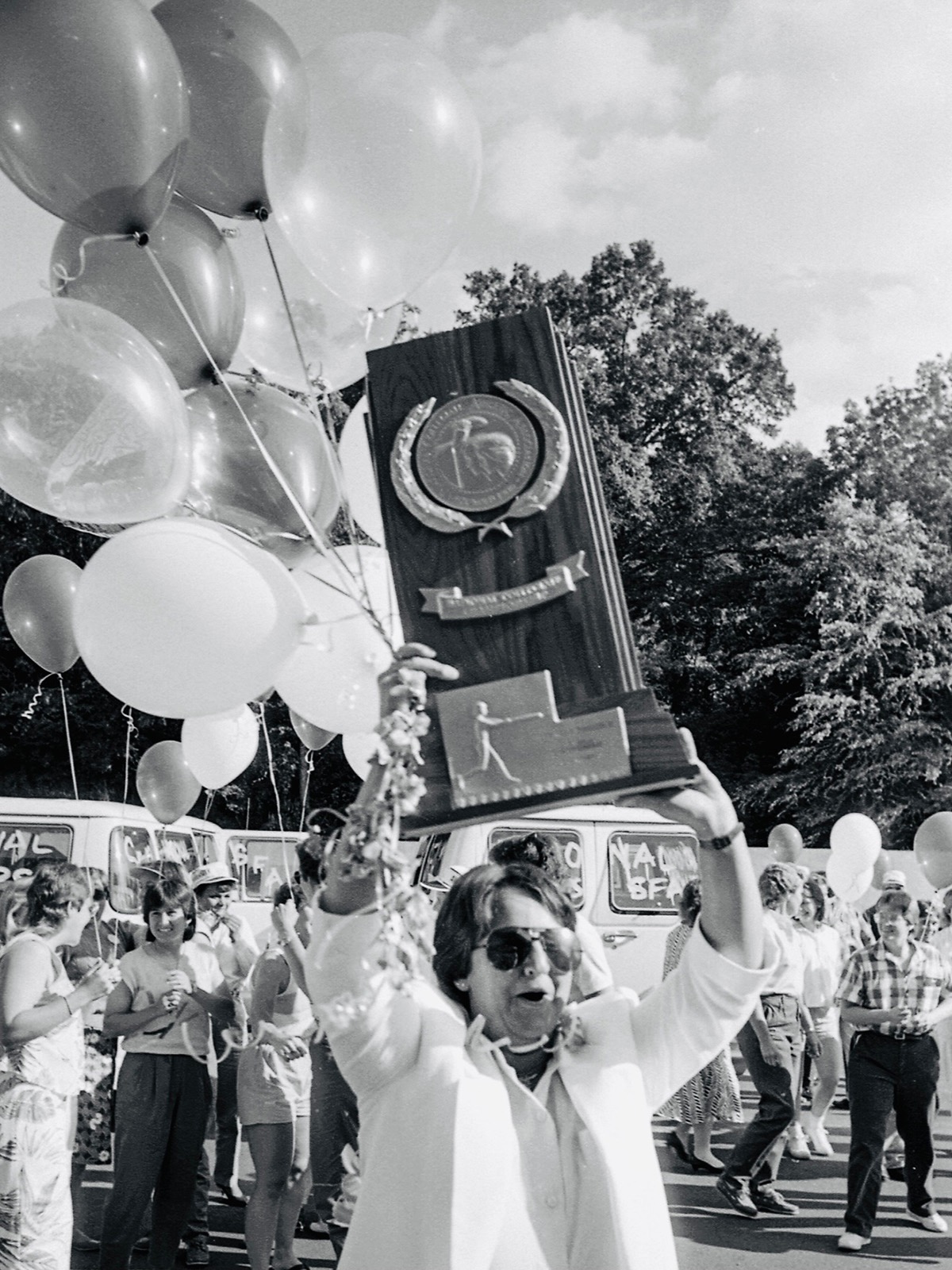 Baker holds up the 1986 Division II national championship trophy that the Stephen F. Austin softball team won.