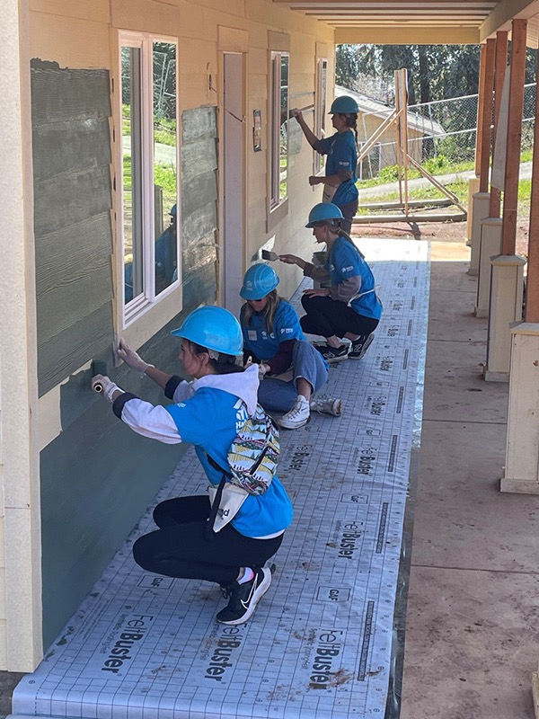 Chico State student-athletes paint the outside of a new home 
