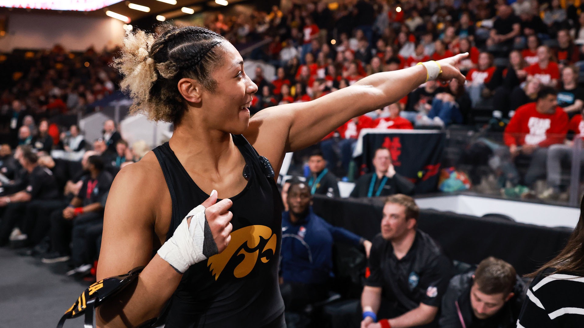 Blades points to a fan during a packed college wrestling match.