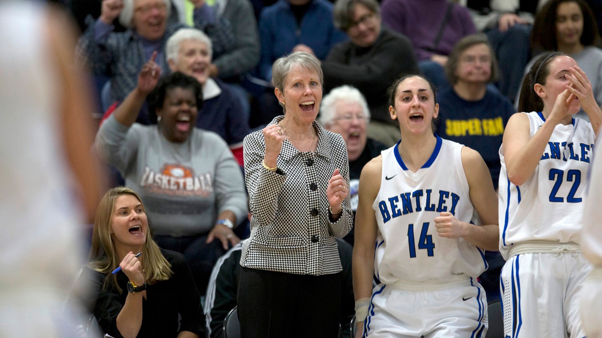 Gosselin (14) celebrates on the bench alongside her head coach, Barbara Stevens, during a game. (Photo courtesy of Bentley)