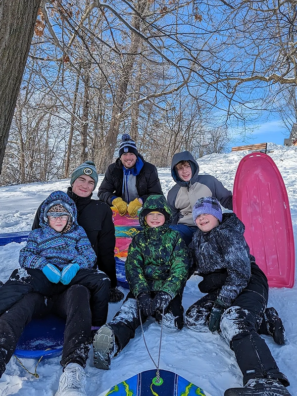 Torin and his siblings sledding with their teammates