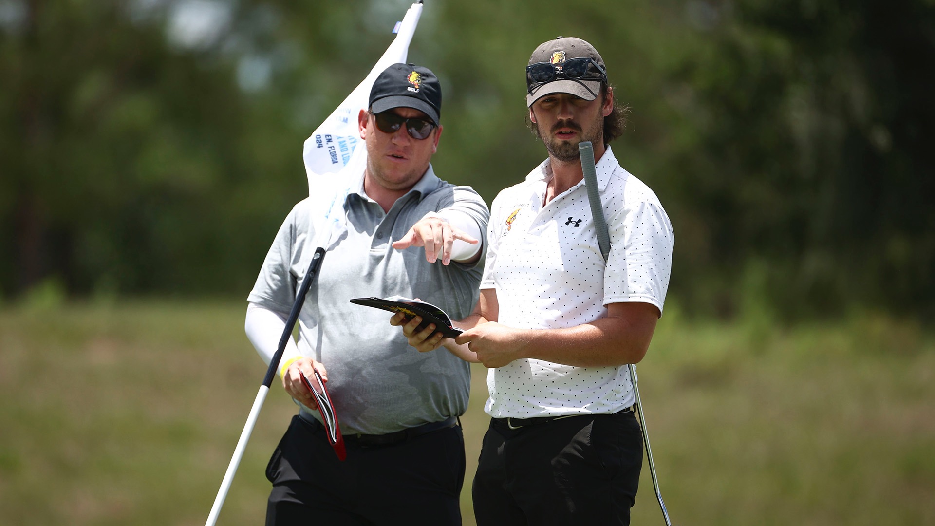 Ferris State coach Sam Stark and senior Nathan Kraynyk survey the course at the 2024 Division II Men's Golf Championships.