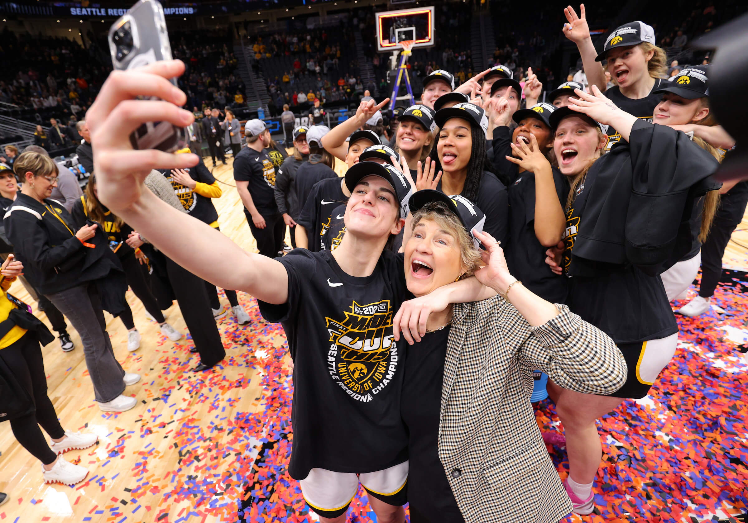 SEATTLE, WA - MARCH 26: Caitlin Clark #22 of the Iowa Hawkeyes takes a selfie with head coach Lisa Bluder after defeating the Louisville Cardinals during the Elite Eight round of the 2023 NCAA Women’s Basketball Tournament held at Climate Pledge Arena on March 26, 2023 in Seattle, Washington. (Photo by Tyler Schank/NCAA Photos via Getty Images)