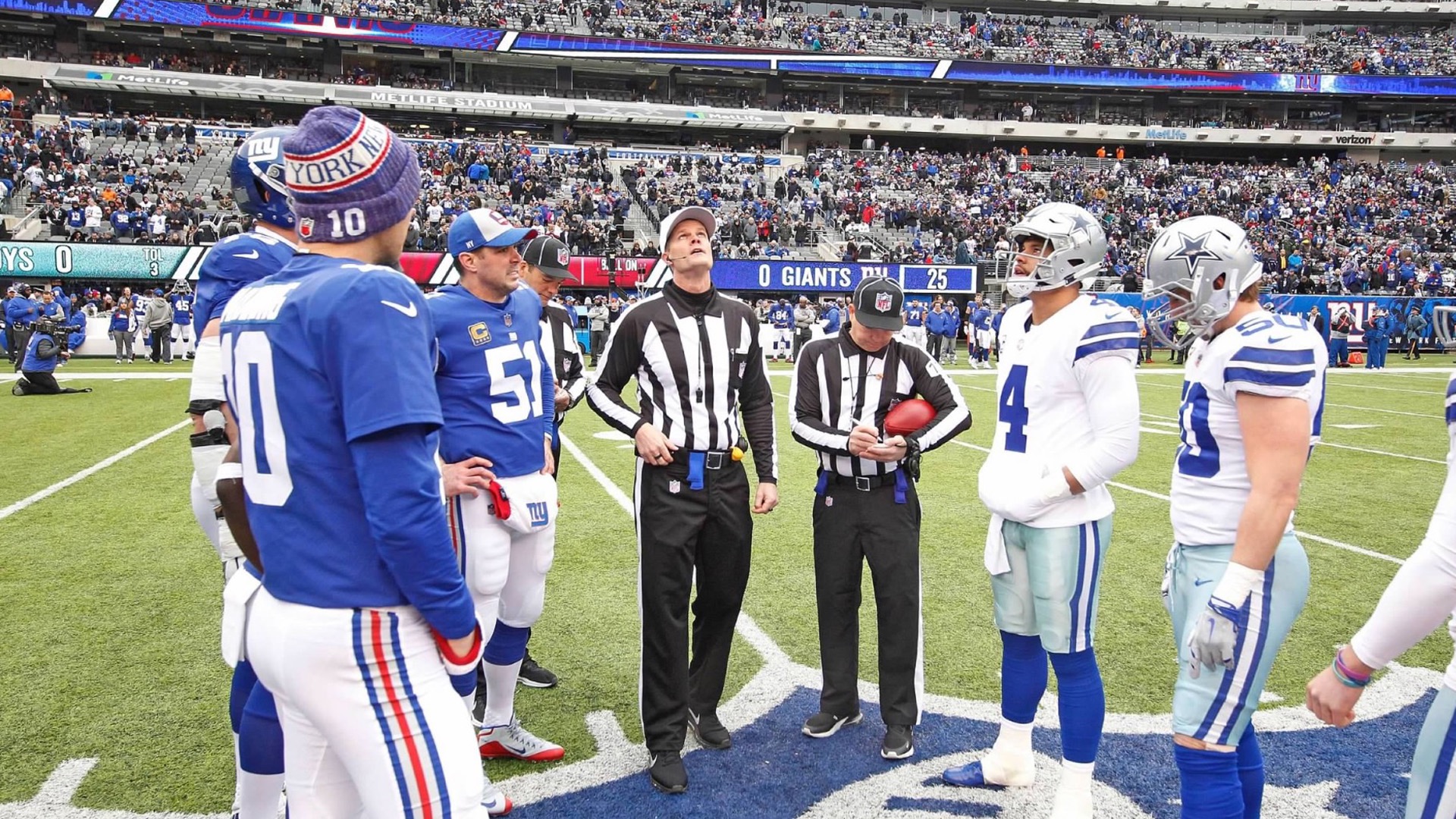 Clay Martin (middle) conducts the coin toss before an NFL game between the New York Giants and Dallas Cowboys in 2018.