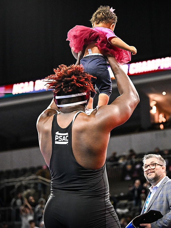 Crosby holds his daughter, Sierra, after winning the Division II heavyweight wrestling title. (Photo courtesy of Gannon)