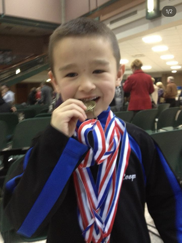 A young Cooper Kim poses with his medals after a meet. (Photo courtesy of Cooper Kim)