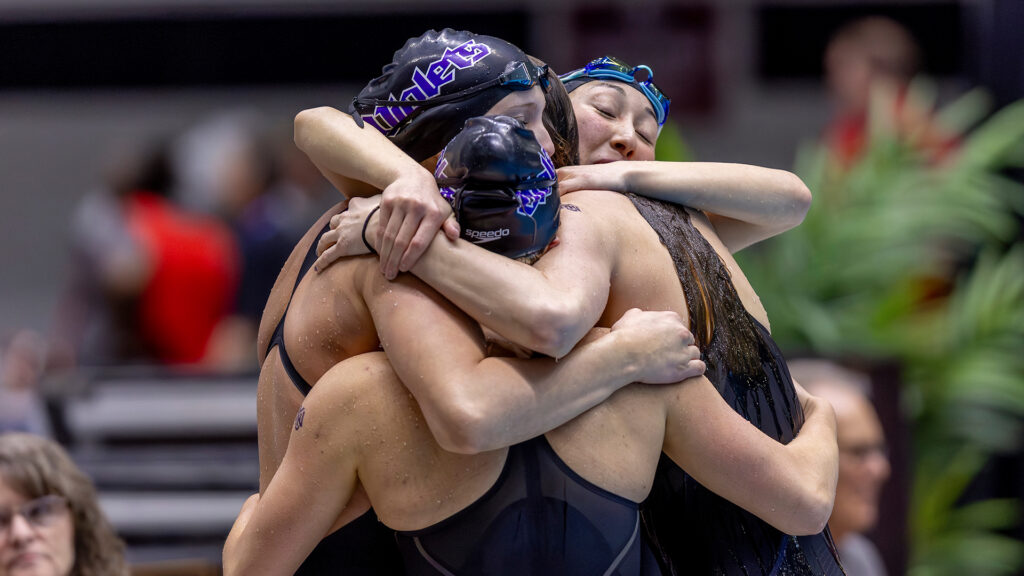 McIntyre embraces teammates on the pool deck. She values the community she found in Division III swimming.