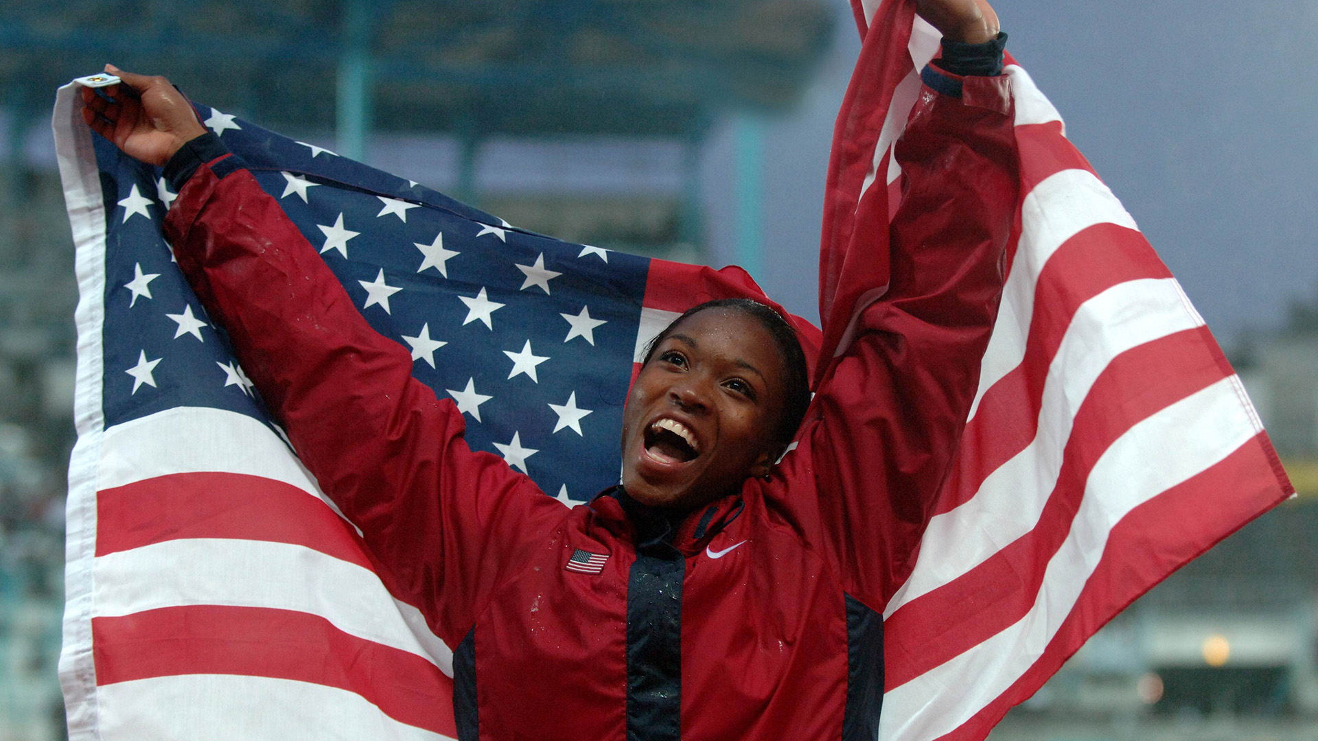 Tianna Madison hoists the American flag after an Olympic victory.