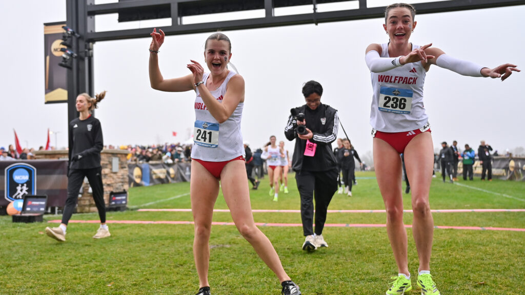 Bethany Michalak and Sadie Engelhardt dance prerace at the Division I Women’s Cross Country Championships. (Photo by Amy Kontras / NCAA Photos)