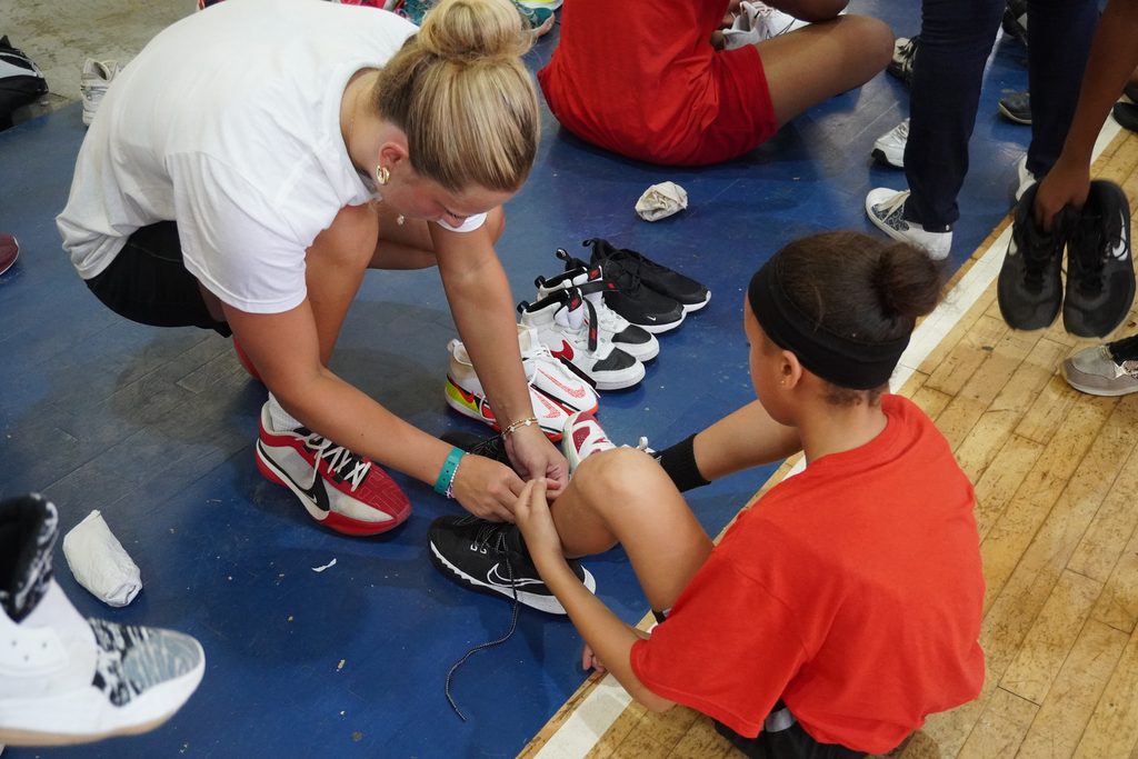 Brooke Adkins laces up a Dominicanas en la Cancha camper’s new shoes in 2026.